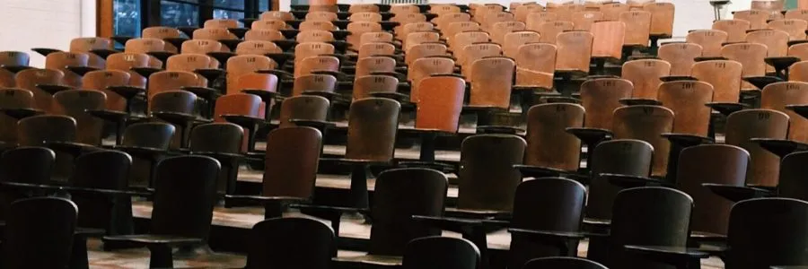 Rows of empty seats in a university lecture auditorium